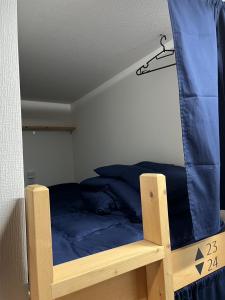 a bedroom with a bunk bed with blue sheets at 広島ゲストハウス Nice Day in Hiroshima