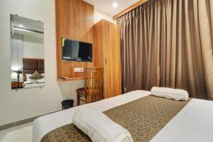 a hotel room with a bed and a flat screen tv at Hotel Sion Fort in Mumbai