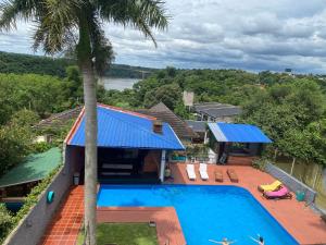 an aerial view of a house with a swimming pool and a palm tree at Guembe al Rio Hostel in Puerto Iguazú