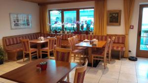 un ristorante con tavoli e sedie in legno e finestre di Landgasthof Sonnegghof a Castelvecchio