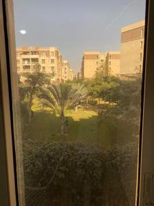 a view of a park with trees and buildings at Luxurious, fully furnished and well equipped apartment with modern amenities, stunning views, and convenient location for remote work or studying from home in Madinaty
