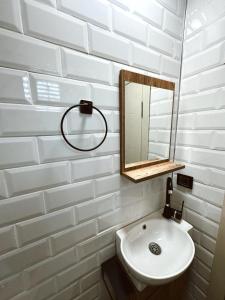 a white bathroom with a sink and a mirror at GÖKÇEADA BADEMİ BUTİK OTEL in Gokceada Town