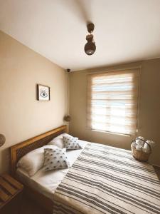 ein Schlafzimmer mit einem großen Bett und einer gestreiften Decke in der Unterkunft GÖKÇEADA BADEMİ BUTİK OTEL in Gokceada Town