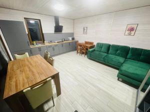 - un salon avec un canapé vert et une table dans l'établissement Гостевой комплекс "Дядя Саша", à Sokirno