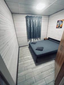 1 dormitorio con 1 cama en una habitación con ventana en Гостевой комплекс "Дядя Саша", en Sokirno