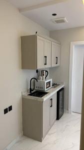 a kitchen with white cabinets and a microwave at غرفة وصالة دخول ذكي العقيق in Riyadh