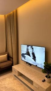 a living room with a flat screen tv on a table at غرفة وصالة دخول ذكي العقيق in Riyadh