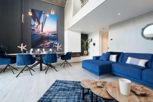 a living room with a blue couch and a table at Captains Boathouse in Harderwijk