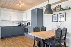 uma cozinha com uma mesa de madeira e cadeiras em Voss Resort - 2br vacation apartment em Skulestadmo