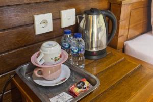 a tray with a tea kettle and a cup on a table at Putri Nusa Beach in Nusa Penida