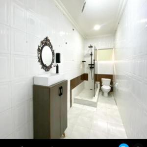 a bathroom with a sink and a toilet and a mirror at Ilewalekki in Lagos