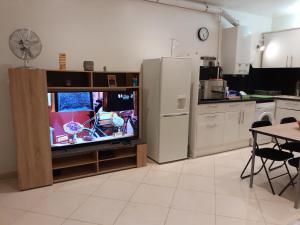 a kitchen with a television in a kitchen with a table at NICOLAS ET MARIE in Courbevoie