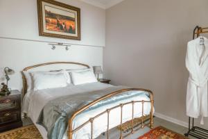 a bedroom with a bed and a painting on the wall at Fig Tree in Pretoria