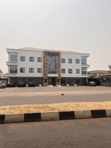 un gran edificio blanco al lado de una carretera en Luxury 2 Bedroom Apartment in the Heart of WUSE 2, WIFI,NETFLIX, 24hrs Light en Abuja