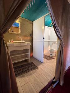 Desert Luxury Camp Experience في مرزوقة: حمام مع حوض ومرحاض