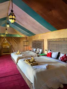 a bedroom with two beds in a tent at Desert Luxury Camp Experience in Merzouga