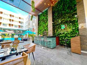Imperial Resort, Eden في الغردقة: مطعم بجدار أخضر وبه طاولات وكراسي