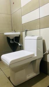 uma casa de banho com um WC branco e um lavatório. em Phoenix Residency, Near MVR Cancer Centre, Vellalassery, NIT, Calicut em Māvūr