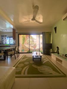sala de estar con sofá y mesa con alfombra en Amina Haus en Sali Poulang