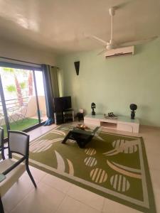 sala de estar con alfombra verde en el suelo en Amina Haus en Sali Poulang