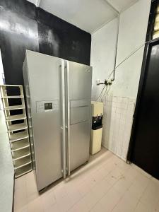 a kitchen with a stainless steel refrigerator in a room at Homestay Syahezzie fully aircond Netflix With Jacuzi in Ampang