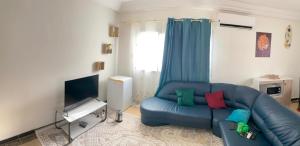 a living room with a blue couch and a television at Studio moderne Rue Marsat in Dakar
