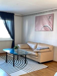 uma sala de estar com um sofá e uma mesa de vidro em Rentalux Apartments in Örnsköldsvik em Örnsköldsvik