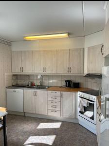 uma cozinha com armários brancos e um forno com placa de fogão em Rentalux Apartments in Örnsköldsvik em Örnsköldsvik