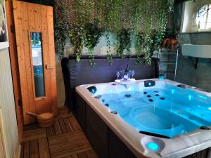 uma banheira de hidromassagem numa casa de banho com plantas em Le Jardin Secret & Spa em Saint-Brieuc