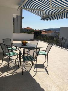 a table and chairs with a bowl of fruit on a patio at Luxury apartment Cairos in Trogir