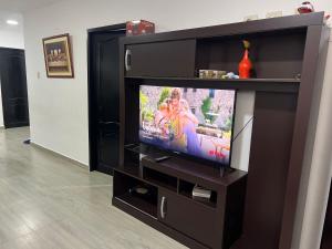 een flatscreen-tv in een zwart entertainmentcentrum bij CaSa PrivaDa con Piscina in Playas