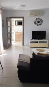 a living room with a couch and a tv at Luxury apartment Cairos in Trogir