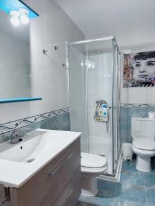 a bathroom with a shower and a toilet and a sink at Apartamento Suite Los Deportes in Ponferrada