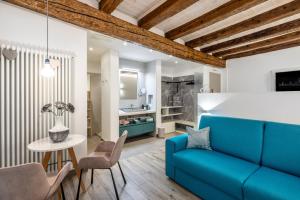 ein Wohnzimmer mit einem blauen Sofa und einem Tisch in der Unterkunft Maison Valentina in Meran