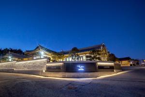 泰安Hotelarrive Taean Tiann HanokBeachResort的晚上，建筑物前有招牌
