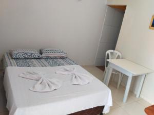 a bedroom with a bed and a table and a chair at casa morada da praia in Xeréu