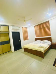 um quarto com uma cama num quarto com janelas em Phoenix Residency, Near MVR Cancer Centre, Vellalassery, NIT, Calicut em Māvūr
