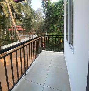 uma varanda com vista para uma palmeira em Phoenix Residency, Near MVR Cancer Centre, Vellalassery, NIT, Calicut em Māvūr