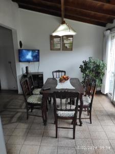 uma sala de jantar com uma mesa de madeira e cadeiras em Alquiler Temporada Casa 2 dormitorios para 6 personas em Mar del Plata