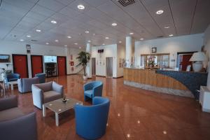 een lobby van een ziekenhuis met blauwe stoelen en een balie bij Hotel Santo Stefano in Bibione