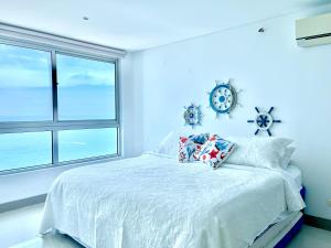 Dormitorio azul con cama y ventana en PALMETTO BEACH, en Cartagena de Indias