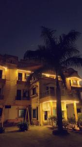 ein großes Gebäude mit einer Palme davor in der Unterkunft Gaurav Resort in Rāmtek