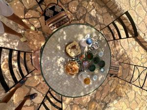 una vista aérea de una mesa de cristal con comida y bebida en Guest House Defat Kasbah, en Aït Ben Haddou