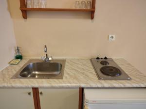 a kitchen counter with a sink and a stove at Elanthi Village Apartments in Kalamaki