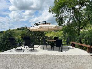 - une table, des chaises et un parasol sur la terrasse dans l'établissement Apartma Fojana, à Dobrovo