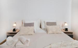 ein Schlafzimmer mit einem weißen Bett und Handtüchern darauf in der Unterkunft Moenia Apartments in Milna