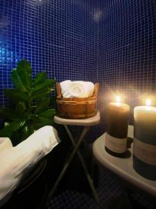 CremenoにあるMonolocale con bagno turco e spazio esterno Studio apartment with turkish bath and external spaceのキャンドル2本とタオルの入ったバスケットが置かれたバスルーム