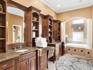 a bathroom with wooden cabinets and a tub and a sink at Playa Panferio in Pensacola Beach +29 photos