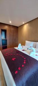 a bedroom with two beds with red rose petals on the bed at Hotel Almas in Marrakech