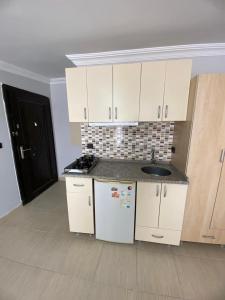 uma cozinha com armários brancos e um lavatório em HERMES OTEL em Edirne